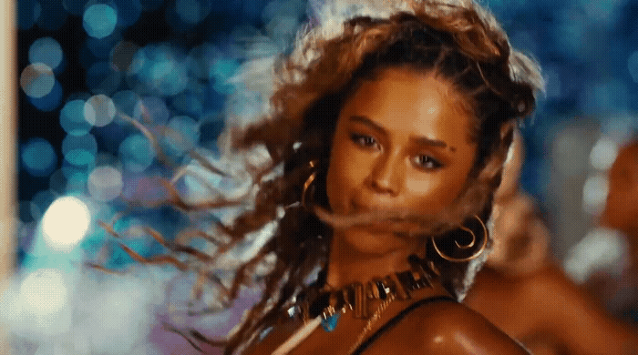 a woman in a bikini top and large hoop earrings