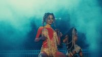 a woman in a red and gold outfit dancing on stage