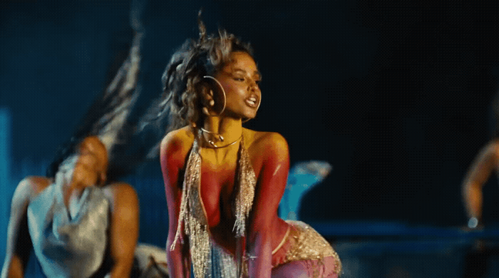 a woman in a red and gold dress is dancing