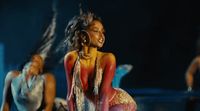 a woman in a red and gold dress is dancing