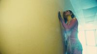 a woman in a long dress leaning against a wall