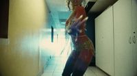 a woman standing in a hallway in a red dress