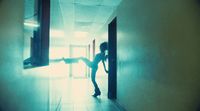 a woman standing in a hallway with her leg in the air