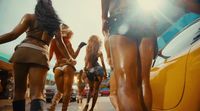 a group of women walking down a street next to a yellow car