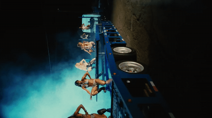 a couple of women laying on top of a blue truck