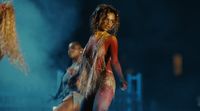 a woman in a bodysuit is dancing on stage