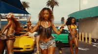 a group of women walking down a street next to a yellow car