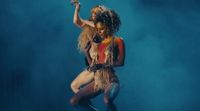 a woman in a costume is dancing on a stage
