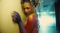 a woman with dreadlocks leaning against a wall