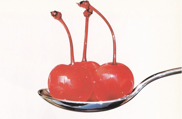 two cherries sitting on top of a spoon