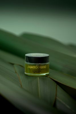 a jar of cream sitting on top of a leaf