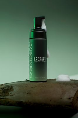 a bottle of shampoo sitting on top of a piece of wood