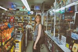 a woman is standing in a store with a bag