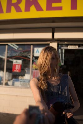 a woman standing in front of a market holding a cell phone