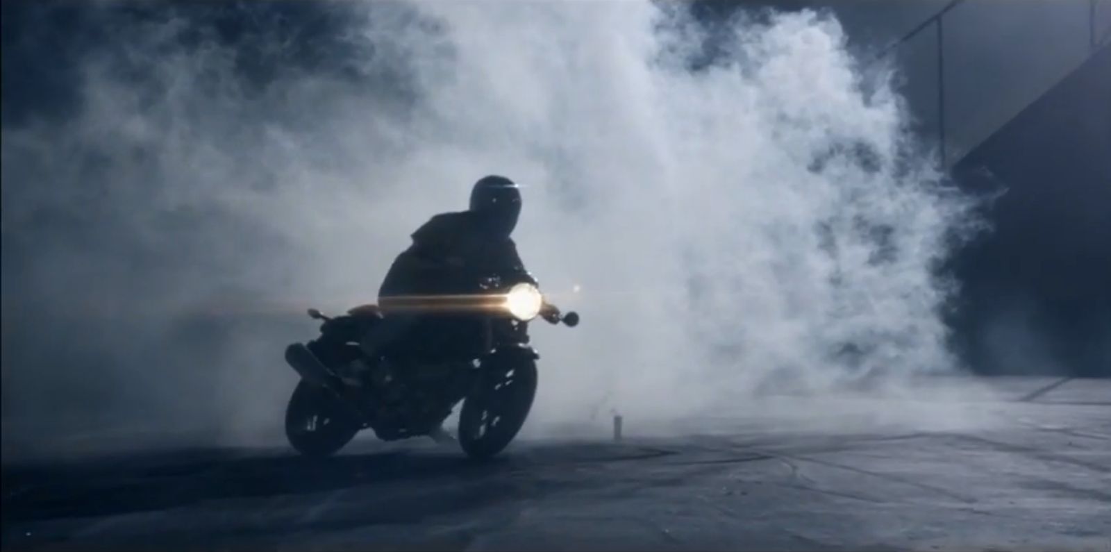 a man riding a motorcycle through a cloud of smoke