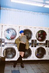 a woman standing in front of a row of washers