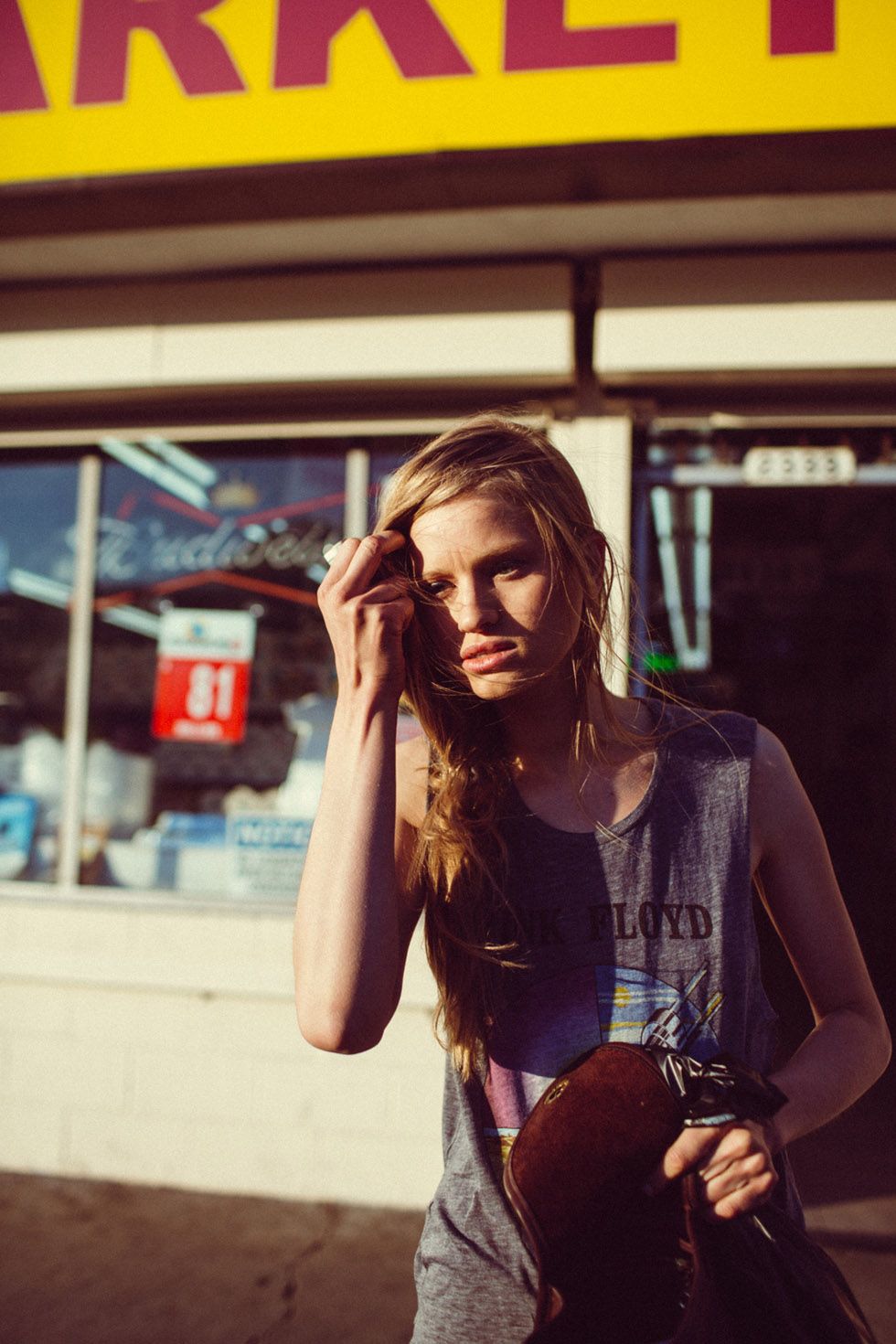 a woman standing in front of a market talking on a cell phone