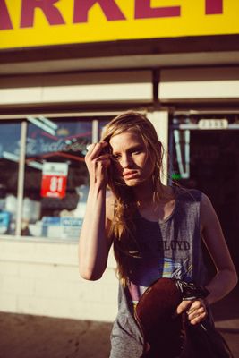 a woman standing in front of a market talking on a cell phone