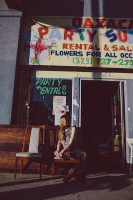 a woman sitting on a chair in front of a rental house