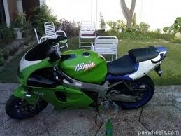 a green and white motorcycle parked on a sidewalk