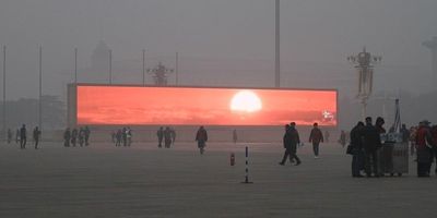 a group of people standing in front of a large screen