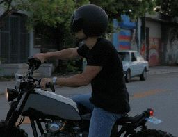 a man riding a motorcycle down a street