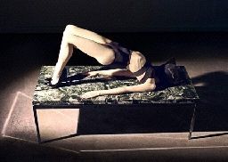 a woman laying on a bed in the dark