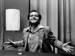 a man sitting at a desk with his arms outstretched