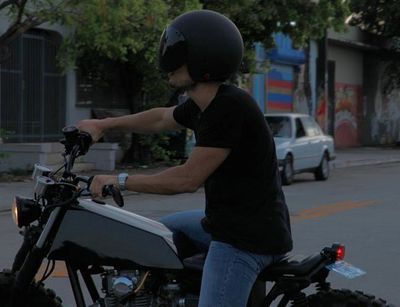 a man riding on the back of a motorcycle down a street