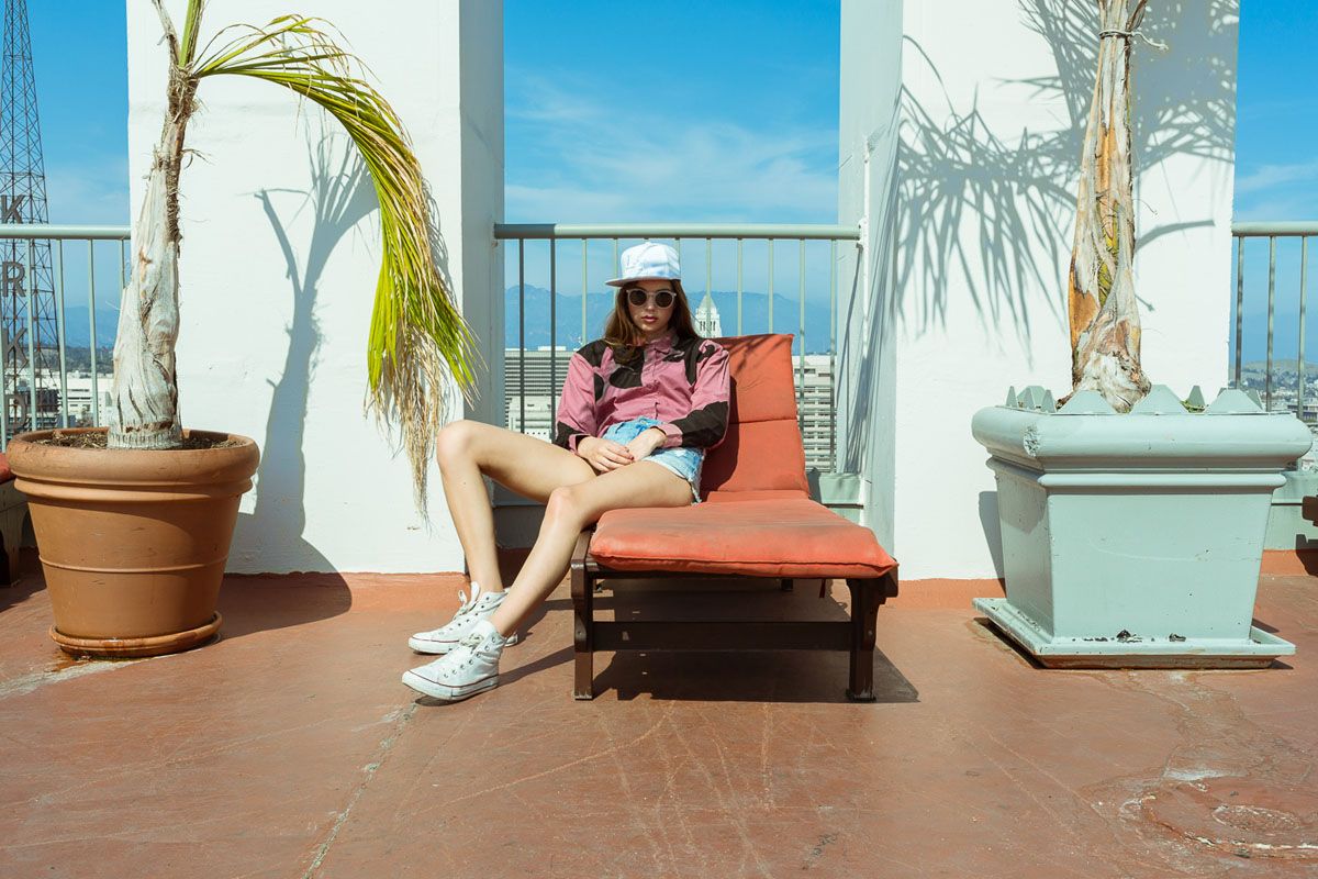 a woman sitting on top of a chair next to a potted plant