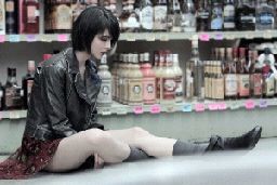 a woman sitting on the ground in front of a store