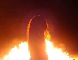 a person standing in front of a large fire