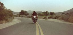 a man riding a motorcycle down a curvy road