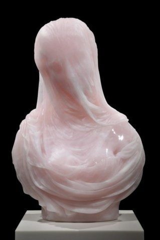 a pink sculpture of a woman's head on a white pedestal