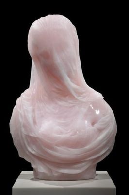 a pink sculpture of a woman's head on a white pedestal