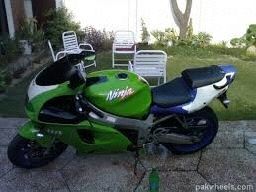 a green and white motorcycle parked on a sidewalk