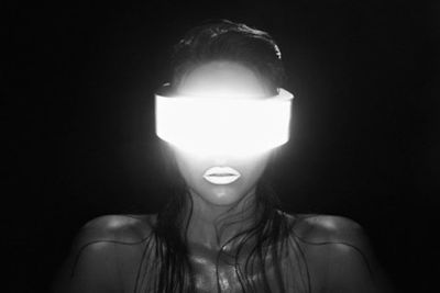 a woman standing in the dark with a light on her head