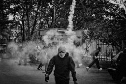 a man walking down a street with smoke coming out of his mouth