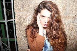 a woman with long hair standing in front of a wall