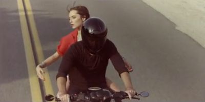 a man and a woman riding on the back of a motorcycle