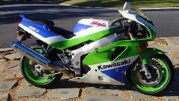 a green and white motorcycle parked on the side of the road