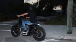 a man riding on the back of a blue motorcycle