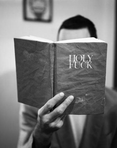 a man holding a book with the words holy fock on it