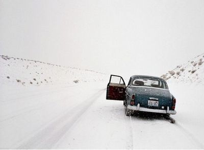 a car driving down a snow covered road