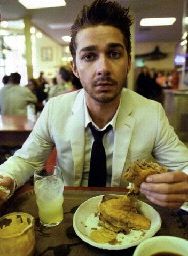 a man sitting at a table with a plate of food