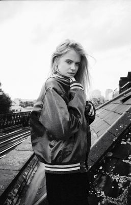 a woman standing on top of a bridge next to train tracks