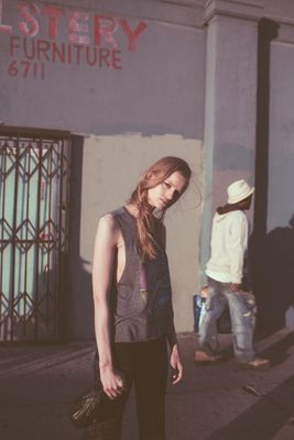 a woman standing on a sidewalk in front of a building