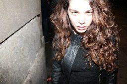 a woman with long hair walking down a street