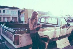 a woman standing in the bed of a pickup truck