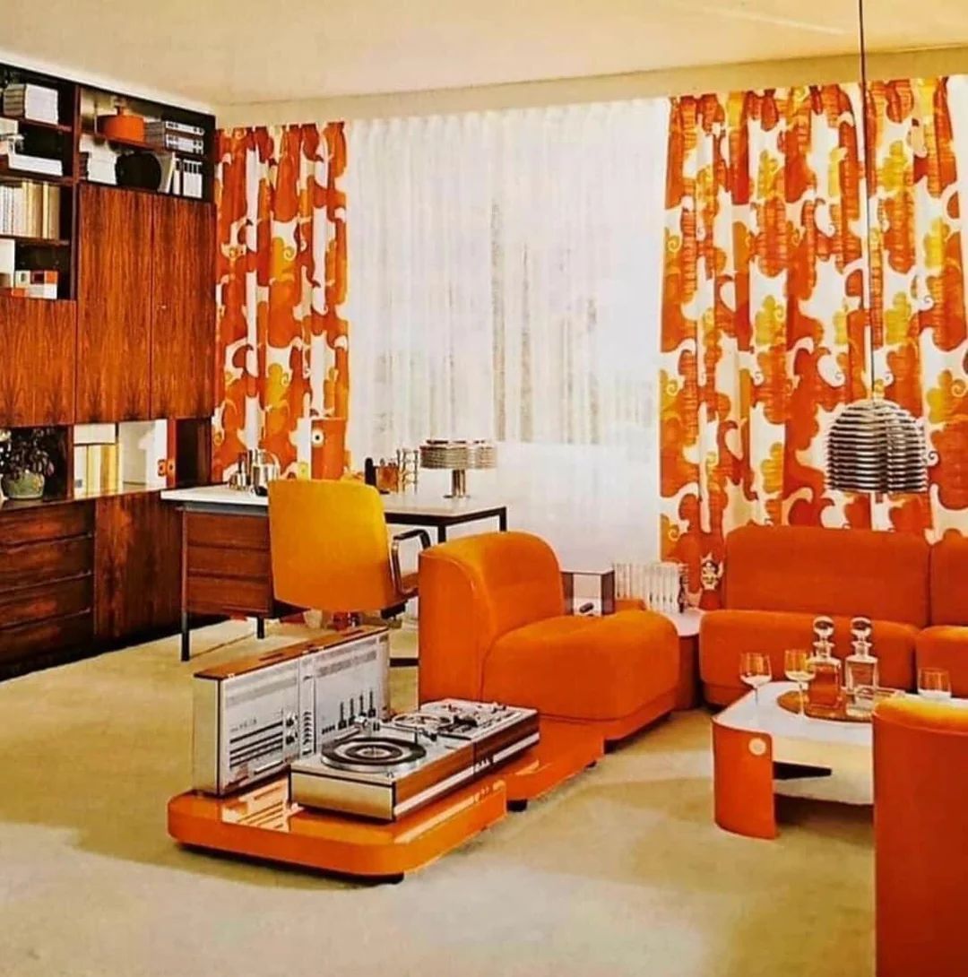 a living room with orange furniture and curtains